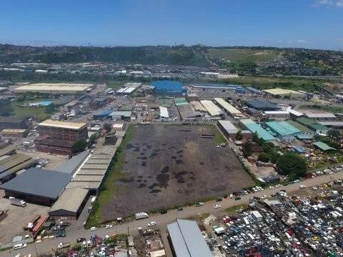 Aerial view of a large vacant site surrounded by industrial buildings