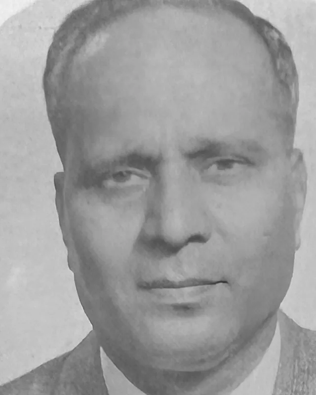 Black and white portrait of Sivalinga Dass in a jacket and tie