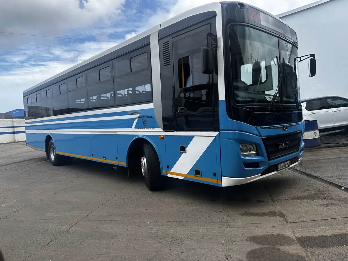 A blue and white Dass Group bus showing the white diagonal band along its side